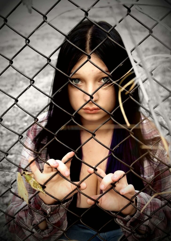 Woman behind chain-link fence